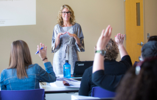 Dawn Comeau, assistant professor of behavioral sciences and health education, is teaching the interns how to conduct a community needs assessment using a curriculum developed by a Rollins student. 