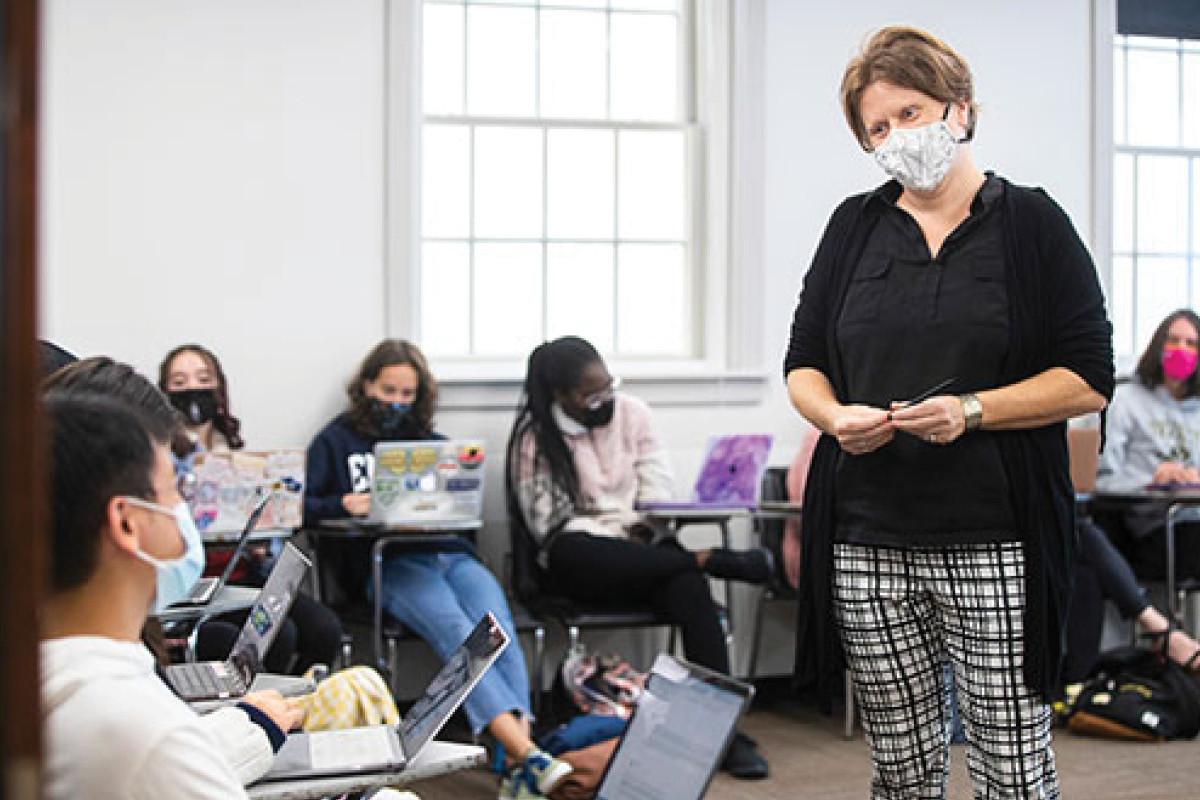 A photo of Dr. Cecile Janssens lecturing a class of masked students