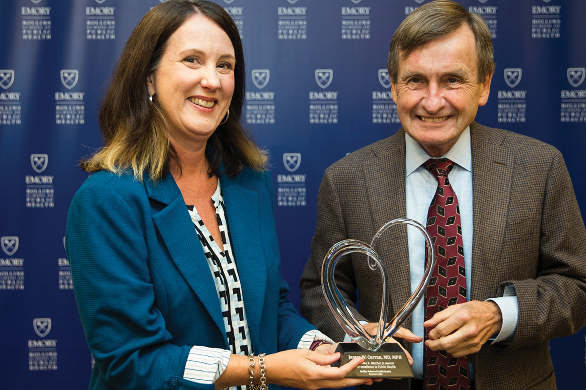 a photo of a woman handing a award statue to the winner a man