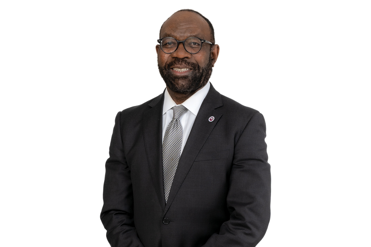 a portrait of an african american man standing tall with his hands in front of him