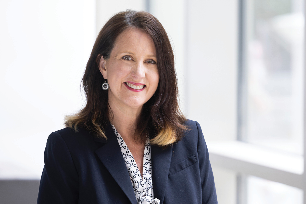 a portrait of the new dean sitting and smiling at the camera