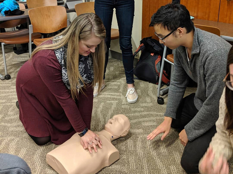 a student practices CPR compression on a dummy