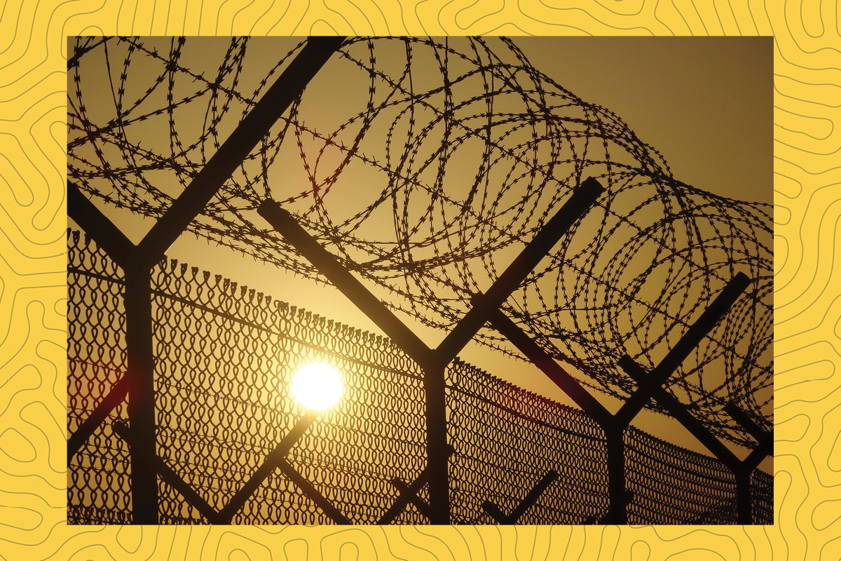 a stock photograph of a prison fence with a hot sun