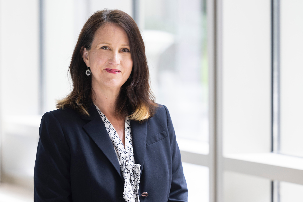 a portrait of the new dean sitting and smiling at the camera